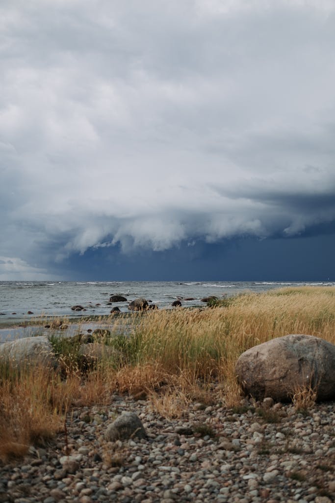 A powerful storm approaches over a rocky coastline, emphasizing nature's dramatic beauty.