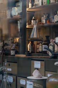 Charming vintage apothecary shop display with bottles and retorts in Lübeck, Germany.