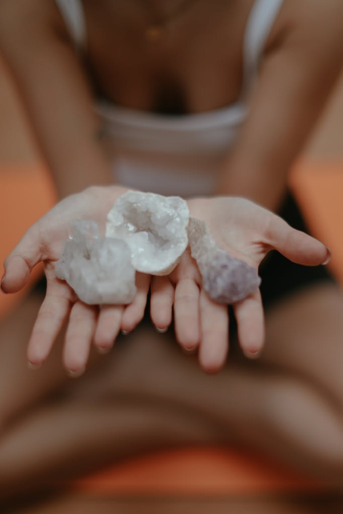 Close-up of crystals in hands, symbolizing mindfulness and meditation, with a blurred background.
