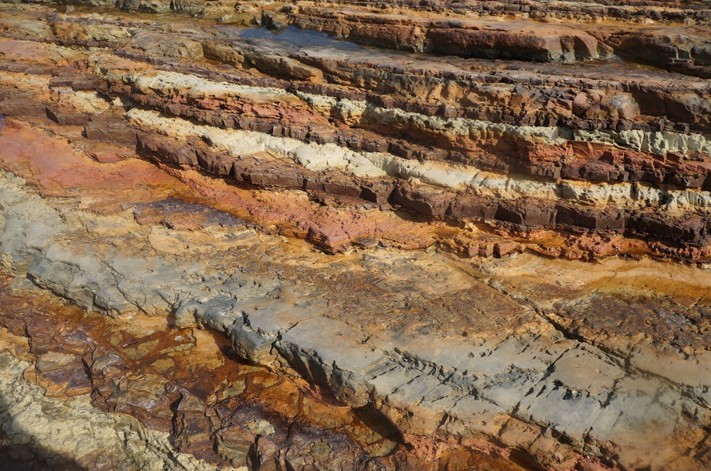 Close-up of exposed layered rock formations with earthy tones, showcasing geological textures.