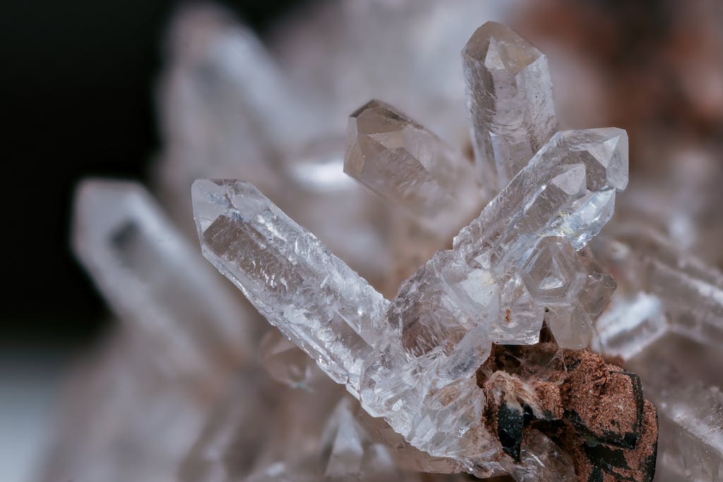 Detailed macro image of a clear quartz crystal cluster with earthy background.