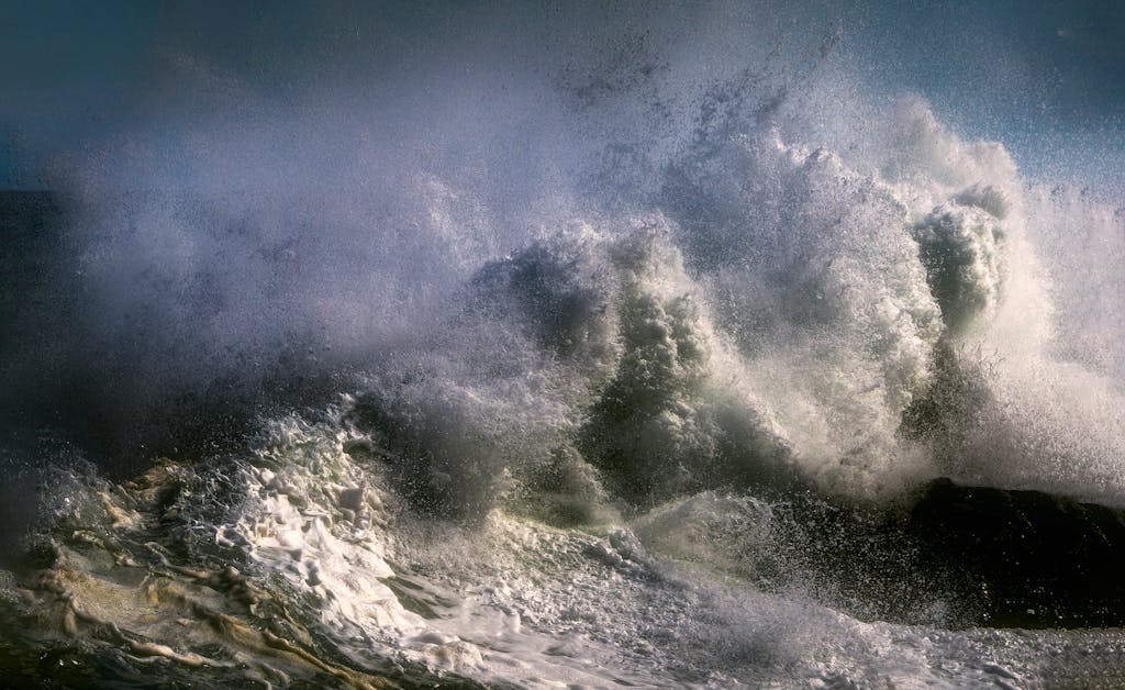 Powerful ocean waves crashing with intense spray and foam, capturing nature's raw energy.