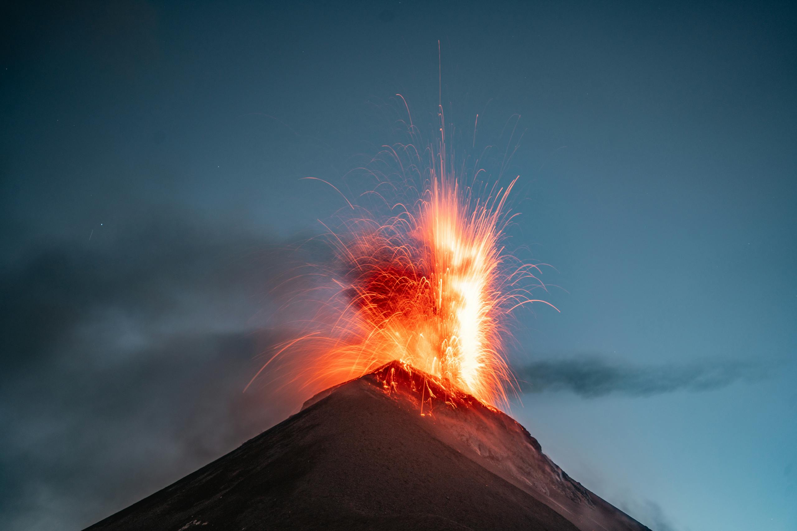 Stunning eruption of Volcán de Fuego in Guatemala, captured with dramatic sparks and lava in the night sky.