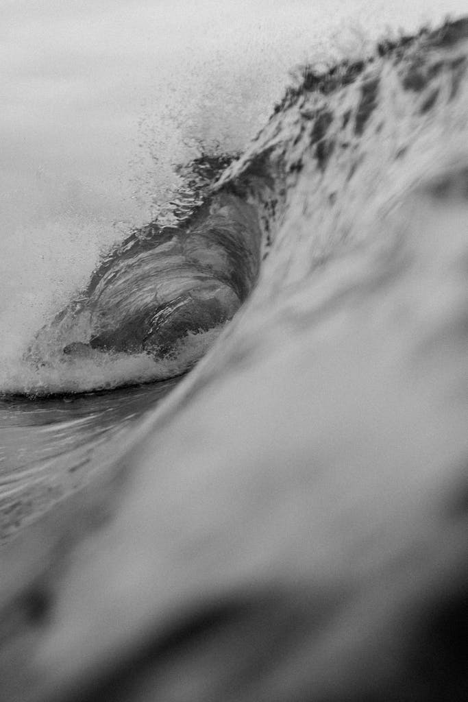 Dynamic close-up of a powerful ocean wave in black and white.
